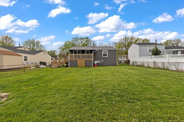 4096 Jonquil St, Columbus, OH 43224 - rear view of house featuring a fenced backyard, a wooden deck, and a lawn