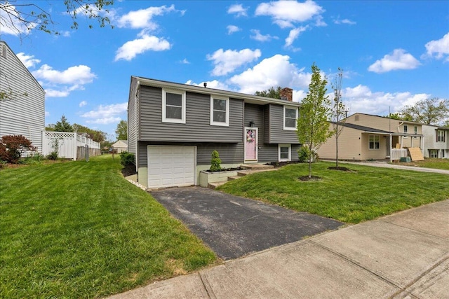 4096 Jonquil St, Columbus, OH 43224 - bi-level home with a garage, a chimney, a front lawn, and aphalt driveway