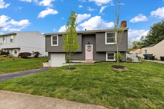 4096 Jonquil St, Columbus, OH 43224 - split foyer home with an attached garage, driveway, a chimney, and a front lawn