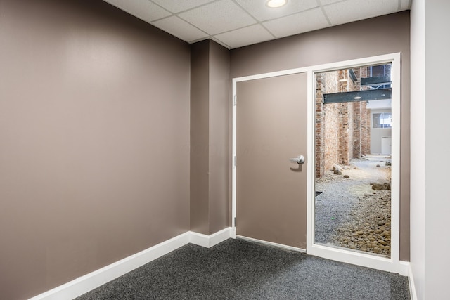 entryway with baseboards, a paneled ceiling, and dark carpet