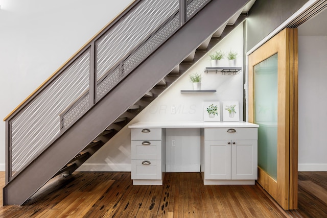 bar with baseboards, dark wood-style flooring, and stairway