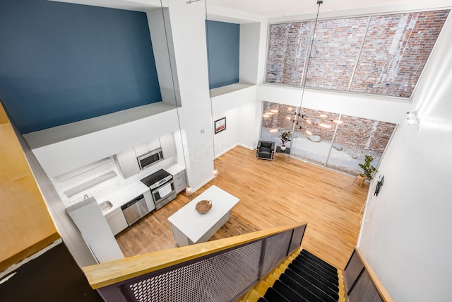 living area featuring a towering ceiling and wood finished floors