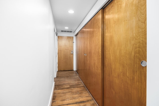 corridor featuring recessed lighting, baseboards, visible vents, and dark wood-style floors