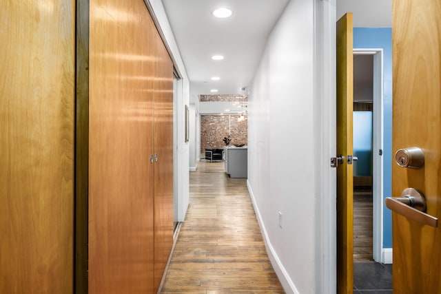 corridor featuring recessed lighting, baseboards, and wood finished floors