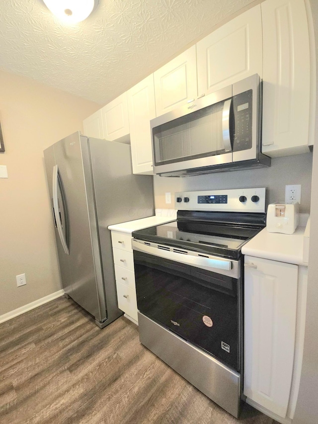 6682 Lagrange Dr Unit 48B, Canal Winchester, OH 43110 - kitchen with light countertops, baseboards, dark wood-style floors, stainless steel appliances, and white cabinetry