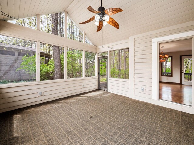 unfurnished sunroom with ceiling fan with notable chandelier