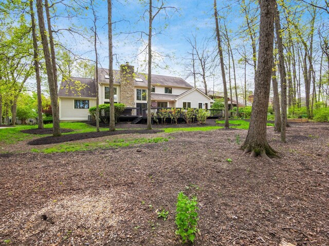 rear view of house with a chimney and a deck