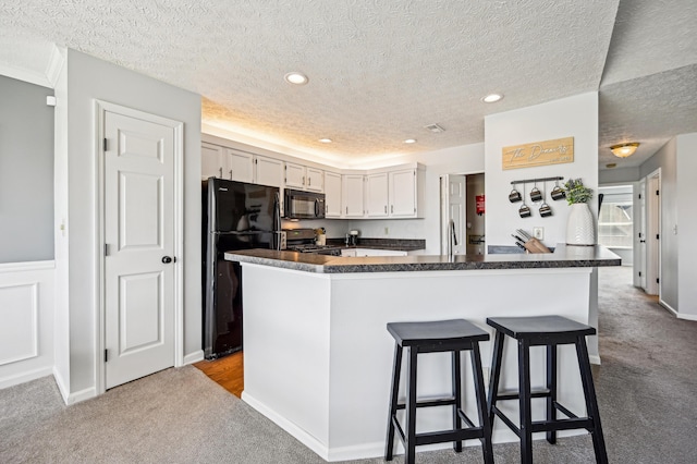 kitchen featuring black appliances, carpet, dark countertops, and recessed lighting