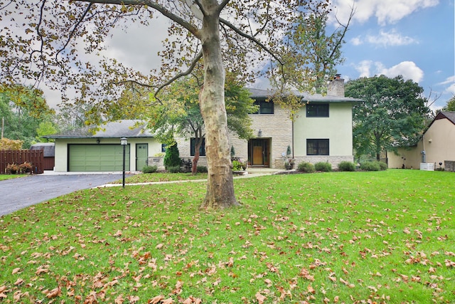 2589 Brookwood Rd, Columbus, OH 43209 - view of front of house with a chimney, stone siding, asphalt driveway, stucco siding, and an attached garage