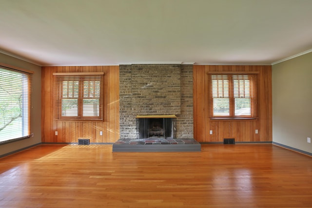 2589 Brookwood Rd, Columbus, OH 43209 - unfurnished living room with wood finished floors, baseboards, crown molding, a fireplace, and wooden walls