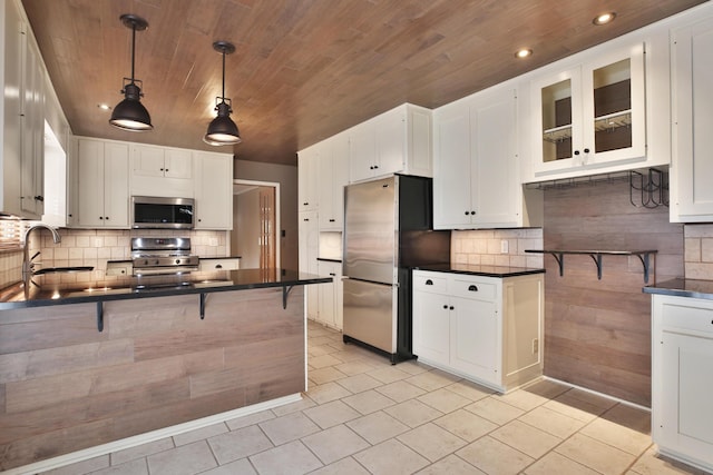 2589 Brookwood Rd, Columbus, OH 43209 - kitchen featuring appliances with stainless steel finishes, dark countertops, wood ceiling, backsplash, and light tile patterned flooring