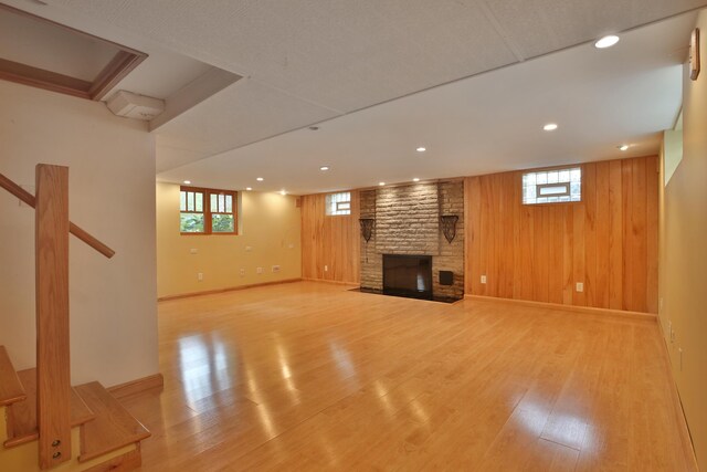 2589 Brookwood Rd, Columbus, OH 43209 - below grade area featuring light wood finished floors, a brick fireplace, wood walls, recessed lighting, and baseboards