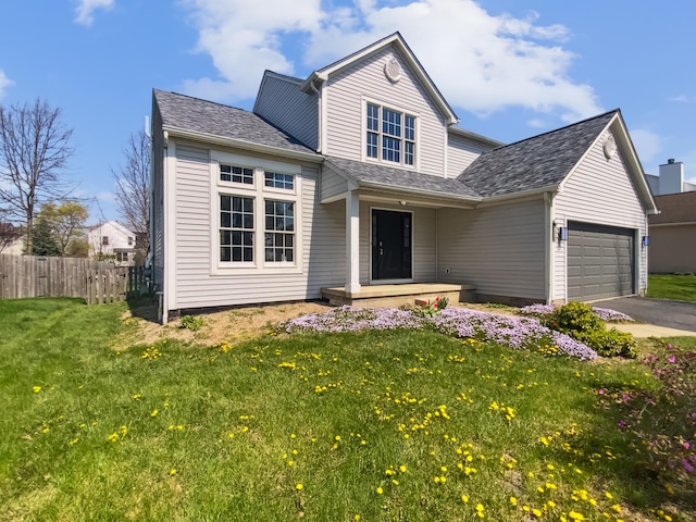 traditional-style home with fence, driveway, a front lawn, and a garage