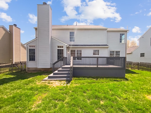 rear view of property featuring a deck, a yard, a fenced backyard, and a chimney