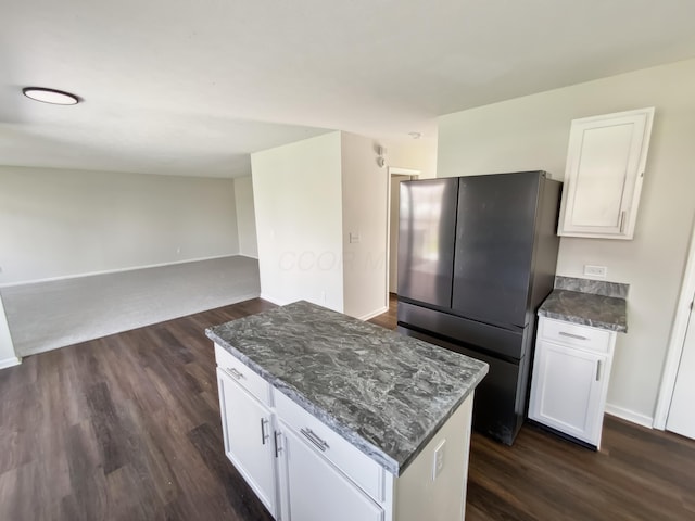 kitchen with white cabinets, freestanding refrigerator, a center island, dark wood-style flooring, and open floor plan