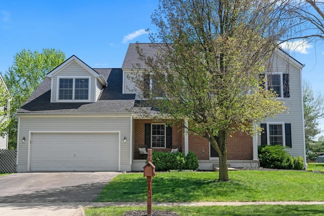 view of front of property with roof with shingles, an attached garage, a front yard, covered porch, and driveway