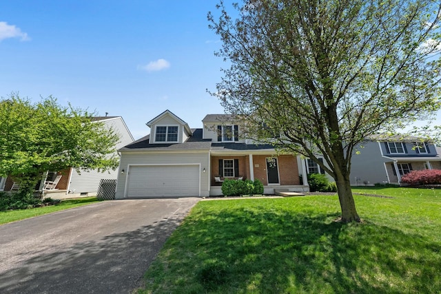 traditional-style house featuring a garage, aphalt driveway, covered porch, and a front yard
