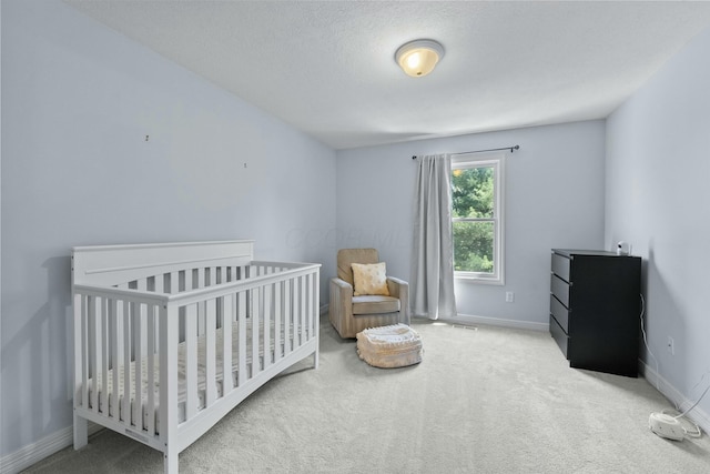 bedroom featuring baseboards, carpet flooring, a textured ceiling, and visible vents