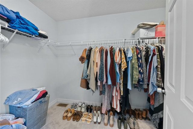 walk in closet featuring visible vents and carpet