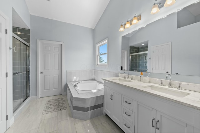 bathroom with double vanity, a sink, a bath, and a stall shower