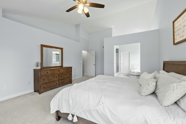 bedroom featuring ceiling fan, light colored carpet, high vaulted ceiling, baseboards, and ensuite bathroom