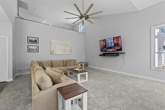 carpeted living room with a ceiling fan, baseboards, visible vents, and high vaulted ceiling