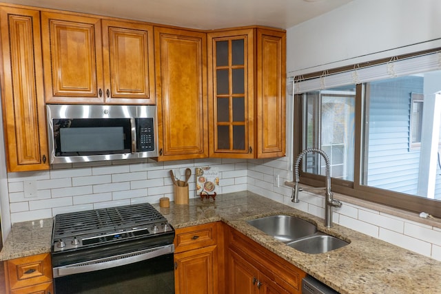 173 S Chesterfield Rd, Columbus, OH 43209 - kitchen with stainless steel microwave, range with gas stovetop, brown cabinetry, and decorative backsplash