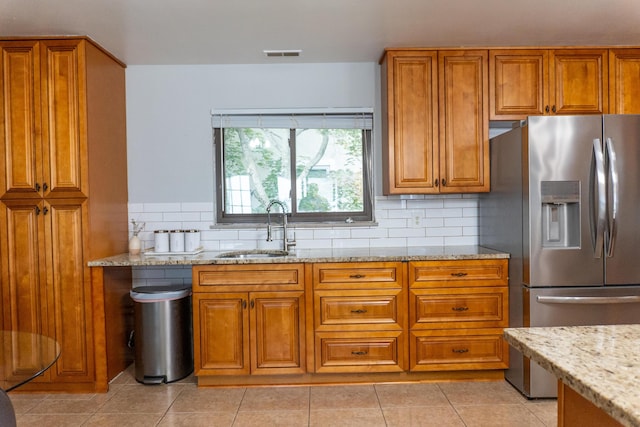 173 S Chesterfield Rd, Columbus, OH 43209 - kitchen featuring stainless steel refrigerator with ice dispenser, a sink, brown cabinets, light stone countertops, and light tile patterned floors