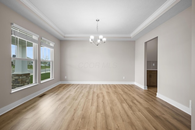 1206 Clover St, Sunbury, OH 43074 - empty room featuring crown molding, a raised ceiling, a notable chandelier, and light wood-type flooring