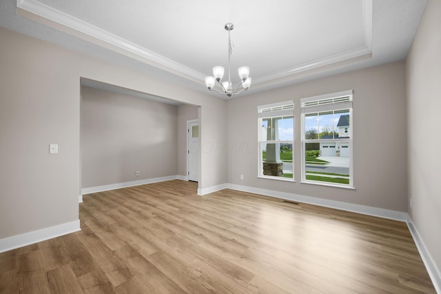 1206 Clover St, Sunbury, OH 43074 - empty room featuring crown molding, a raised ceiling, and an inviting chandelier