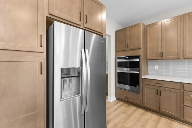 1206 Clover St, Sunbury, OH 43074 - kitchen with light countertops, tasteful backsplash, stainless steel appliances, and light wood-type flooring