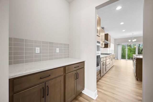 1206 Clover St, Sunbury, OH 43074 - kitchen with light wood-style floors, recessed lighting, light stone counters, appliances with stainless steel finishes, and backsplash