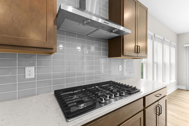 1206 Clover St, Sunbury, OH 43074 - kitchen featuring decorative backsplash, light wood-style flooring, wall chimney range hood, and stainless steel gas stovetop
