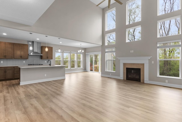 1206 Clover St, Sunbury, OH 43074 - unfurnished living room with a fireplace, light wood-style floors, a sink, and a towering ceiling