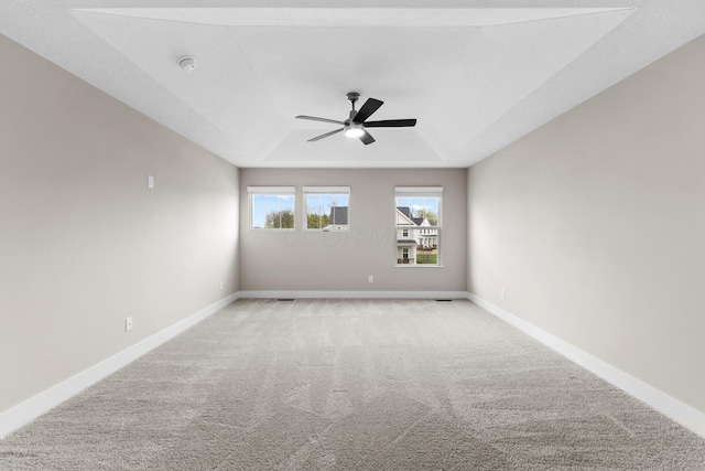 1206 Clover St, Sunbury, OH 43074 - spare room featuring a raised ceiling, baseboards, a ceiling fan, and light colored carpet