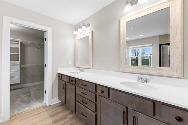 1206 Clover St, Sunbury, OH 43074 - bathroom with double vanity, a walk in closet, visible vents, and a sink
