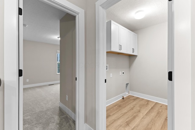 1206 Clover St, Sunbury, OH 43074 - clothes washing area with baseboards, a textured ceiling, cabinet space, and hookup for an electric dryer