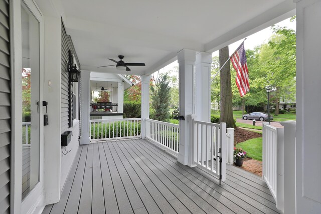 wooden deck with a porch and a ceiling fan