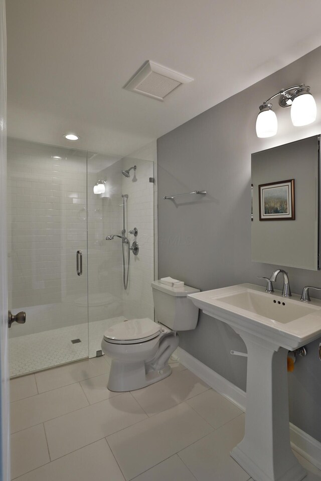 full bathroom featuring toilet, a shower stall, baseboards, tile patterned flooring, and a sink