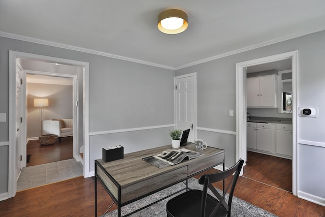 office space featuring dark wood finished floors, crown molding, and baseboards