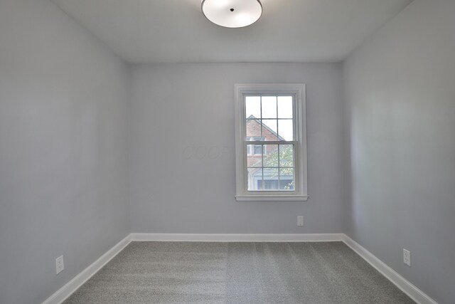 carpeted spare room with baseboards
