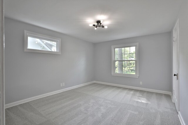 spare room featuring carpet floors and baseboards
