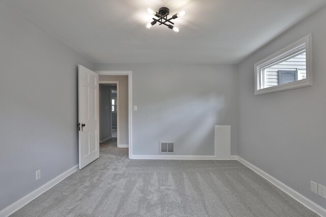 spare room featuring carpet floors and baseboards