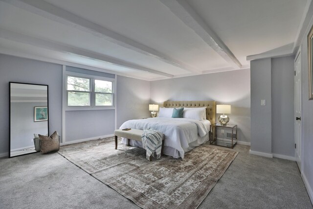 carpeted bedroom featuring beam ceiling and baseboards