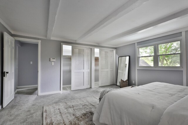 carpeted bedroom with beamed ceiling and baseboards
