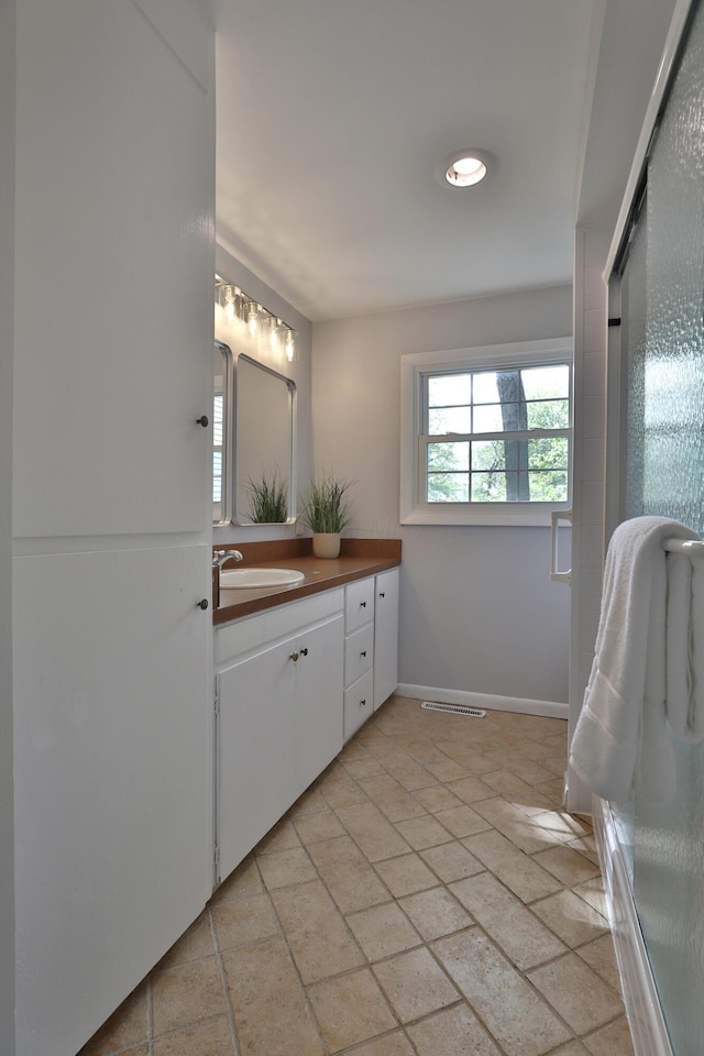 bathroom with vanity, baseboards, and stone finish floors