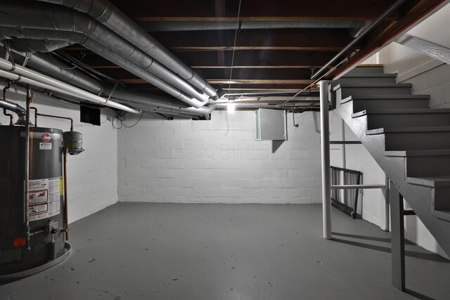 unfinished basement featuring water heater, stairs, electric panel, and concrete block wall
