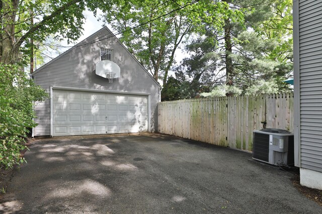 detached garage featuring fence and central air condition unit