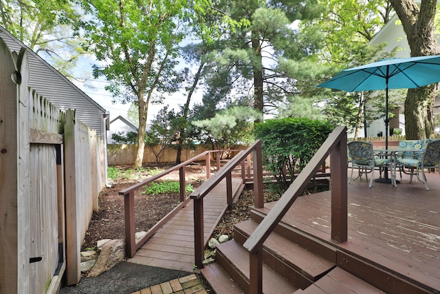 wooden deck with a fenced backyard and outdoor dining area