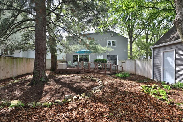 back of house featuring fence and a deck